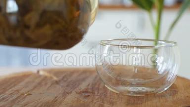 喝茶。 茶被倒入玻璃透明茶杯中。 喝茶的时候。 透明玻璃茶壶和茶杯。